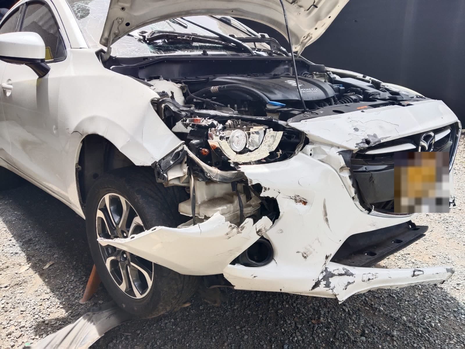 Mazda blanco con daño frontal severo al ingresar al taller