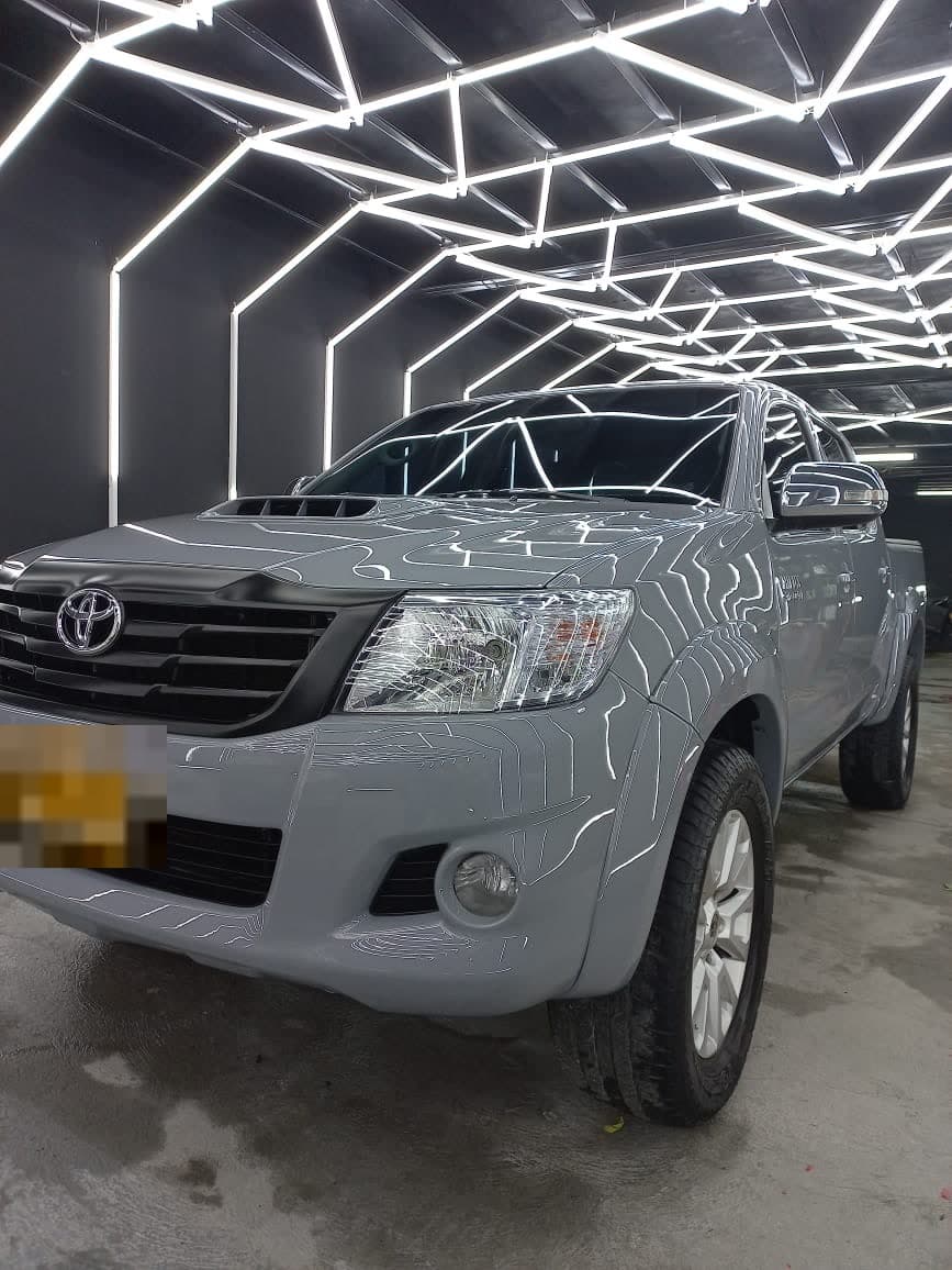 Toyota Hilux gris plata bajo el túnel de luces LED