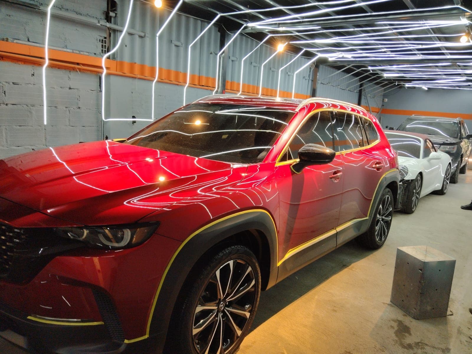 Mazda CX-5 rojo recién terminado en el túnel de luces del taller Ruta 62
